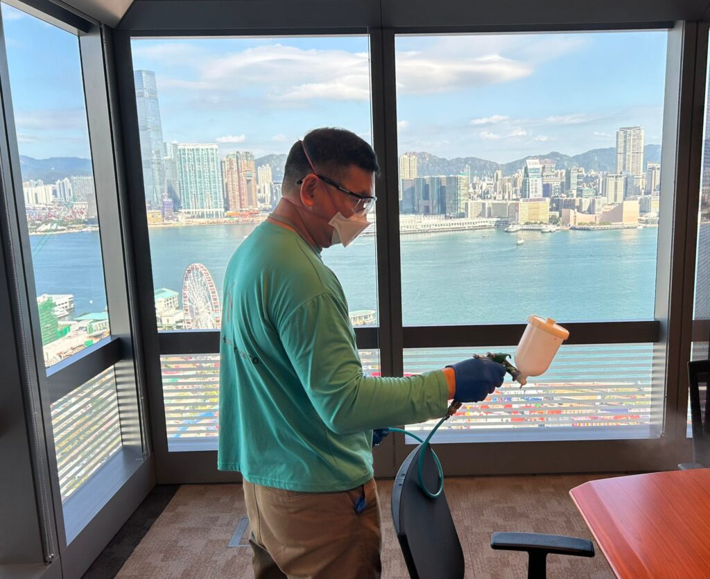 專業人員在室內進行除甲醛噴塗作業，配戴防護口罩與手套